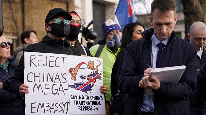 Göstericiler, Londra'da yeni Çin büyükelçilikinin açılmasına karşı düzenlenen bir protestoya katılırken ellerinde pankartlar ve bayraklar tutuyor, 17 Ocak 2026.